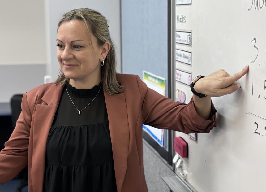 Educator Joanne Gibson pointing to number 3 on whiteboard.
